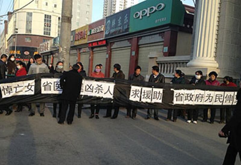 包世蘭疑遭延誤搶救致死,數十名家屬周五(3月8日)到西寧市政府打橫額,要求當局提供協助追究醫院責任。(由家屬楊女士提供)