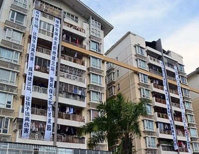 深圳理想新城業主不滿政府於屋苑外興建”三站”影響民居。有居民於屋苑大樓外掛出大幅維權標語。 (居民李先生提供)