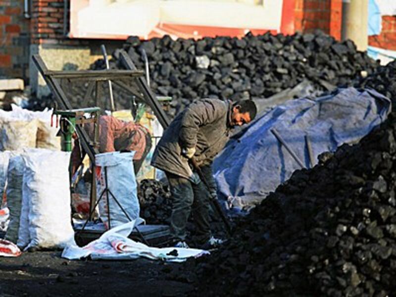 A Chinese worker levels coal at a coal yard in Jinhu county, east China's Jiangsu province, Feb. 2, 2016. 