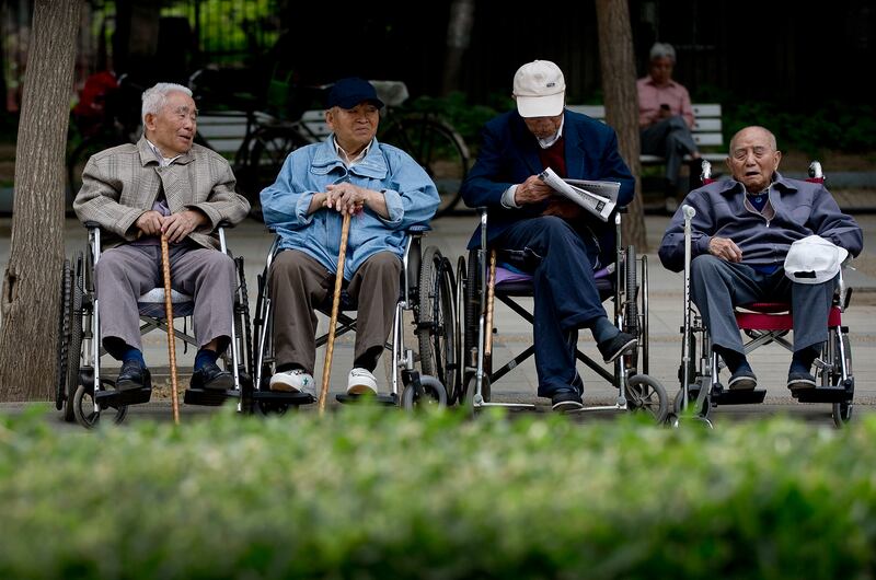 在北京的一个公园里，老年人坐在轮椅上休息。