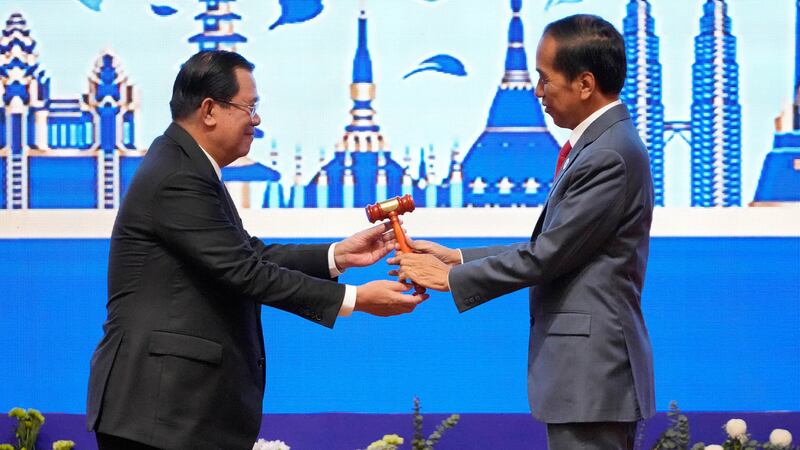 Hun Sen, left, hands over the gavel to Indonesian President Joko Widodo during a transfer of ASEAN Chairmanship during the closing ceremonies of the 40th and 41st ASEAN Summit in Phnom Penh, Cambodia, Sunday, Nov. 13, 2022 by AP-1.jpg