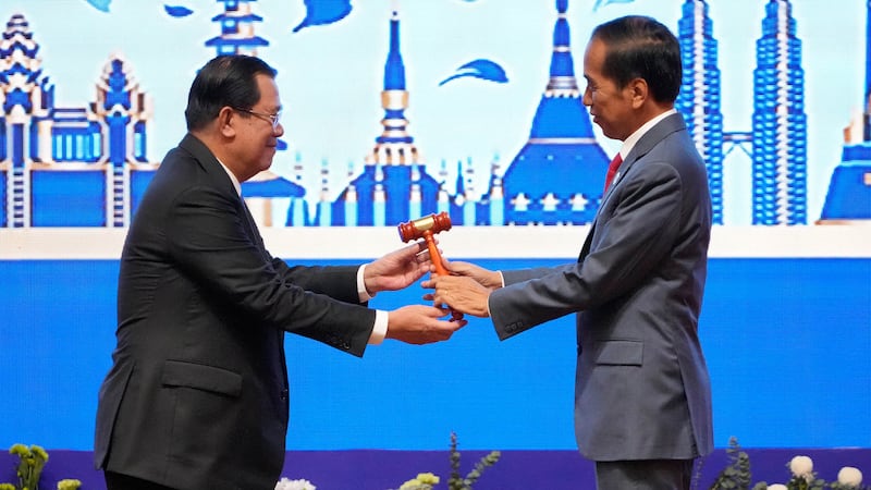 Hun Sen, left, hands over the gavel to Indonesian President Joko Widodo during a transfer of ASEAN Chairmanship during the closing ceremonies of the 40th and 41st ASEAN Summit in Phnom Penh, Cambodia, Sunday, Nov. 13, 2022 by AP-1.jpg