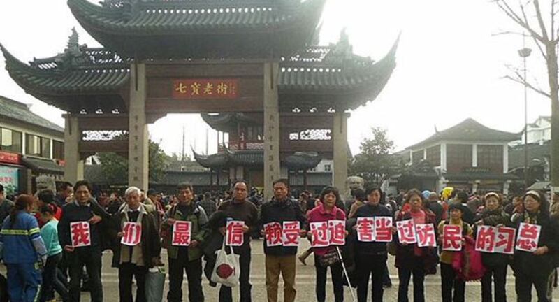 2014年2月1日，數十上海訪民，趁周六大年初二，集體到上海旅遊景點七寶鎮老街，向國家總書記習近平申冤。他們舉起寫有“我們最信賴受過迫害當過訪民的習總”的標語，吸引大批旅客圍觀拍照。（訪民攝）
