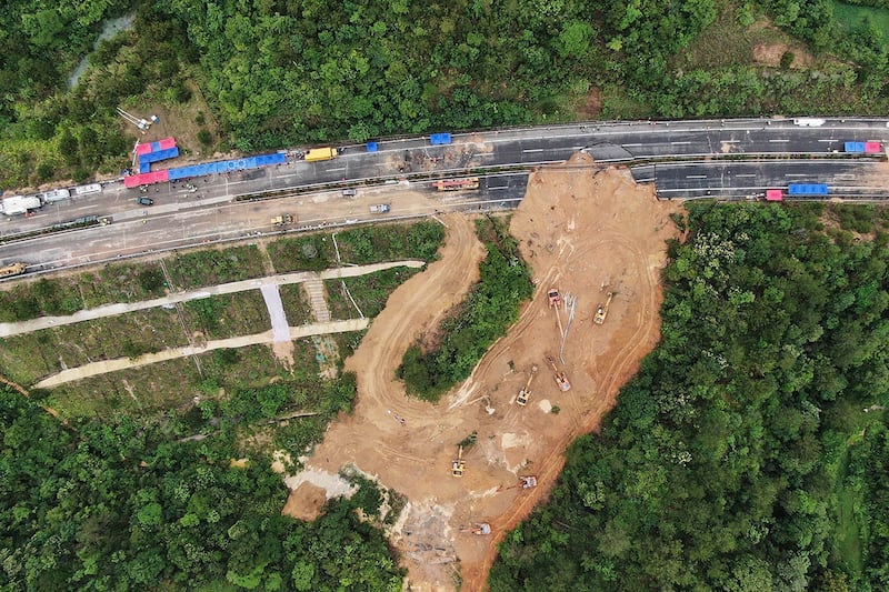2024年5月2日,救援人员和挖掘机在广东梅州梅大高速公路塌方路段现场工作。(美联社)