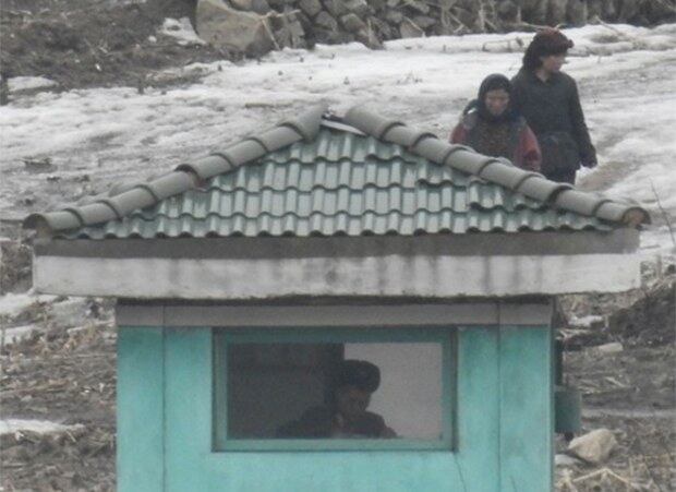 중국 단둥시 외곽에 위치한 수풍댐 인근에서 바라본 북한 평안북도 삭주군에서 한 초소 너머로 어디론가 이동하는 주민들의 모습이 보인다.