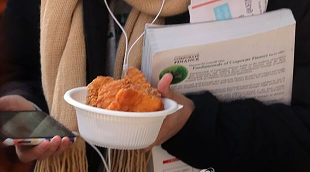 이화여자대학교 학생회관 앞에 한 학생이 무료 치킨을 받고 있다.