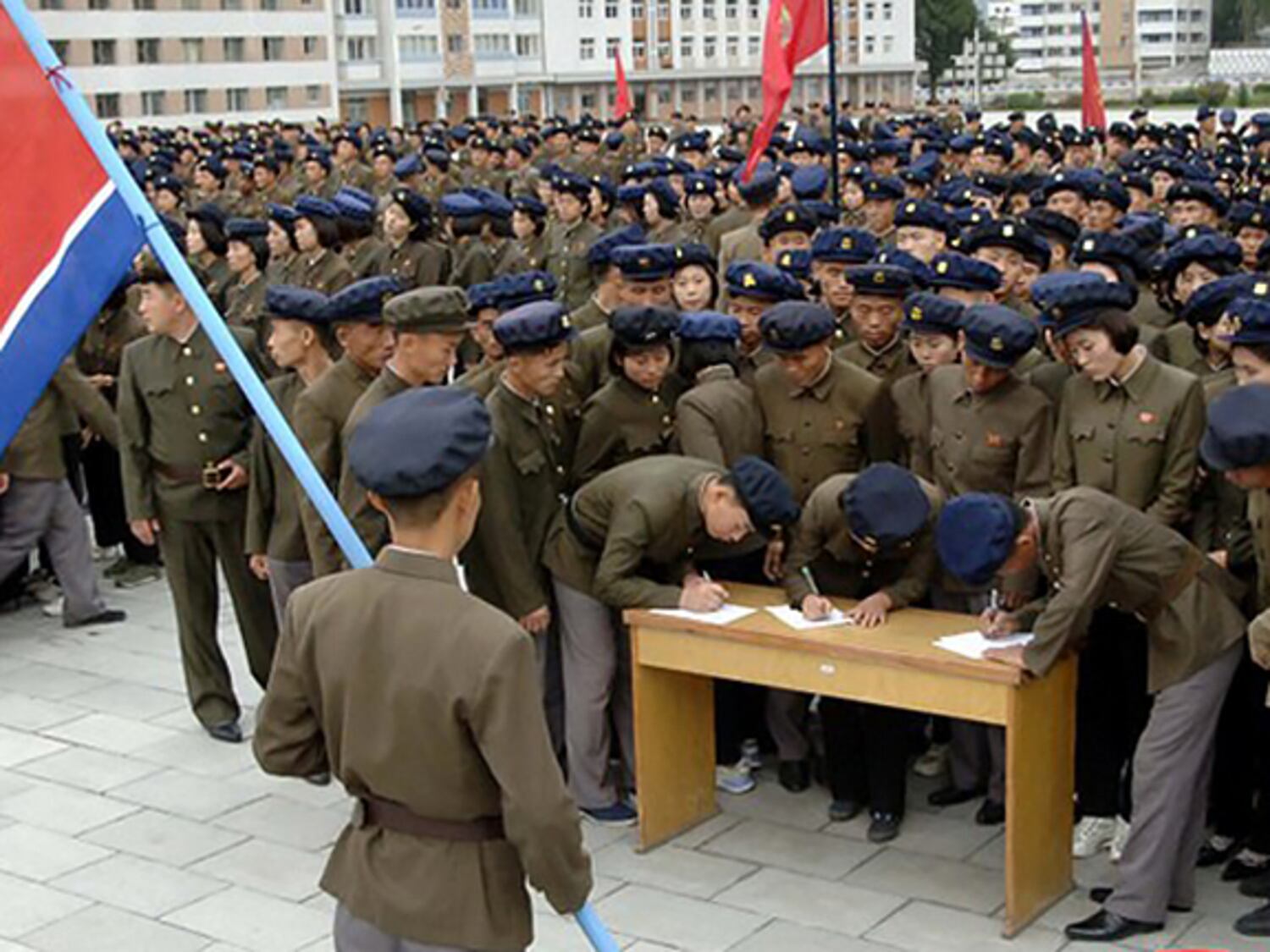 Young people, including students and youth league officials, sign petitions to join the army, according to North Korean state media, at an undisclosed location in North Korea, in undated photo.