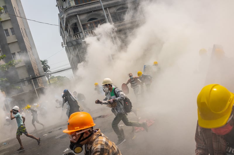 Anti-coup protesters react after riot police fired tear gas to disperse them on March 2, 2021 in Yangon, Myanmar.