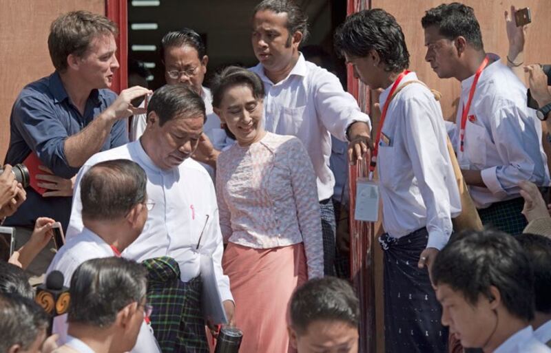 Lãnh tụ đối lập bà Aung San Suu Kyi rời khỏi trụ sở của Liên đoàn Quốc gia Dân chủ (NLD) đang được bao vây bởi báo chí vào ngày 09 tháng 11 2015.