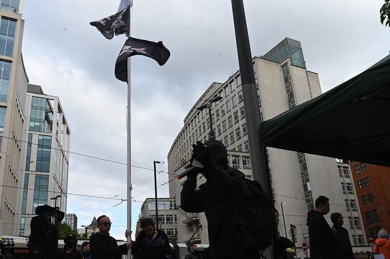 集会期间，现场升起写着"光复香港，时代革命"的旗帜，象征港人抵抗中共极权的黑色洋紫荆旗，以及被部份抗争者视为"香港共和国"象征的蓝白旗帜。 （记者梁铭康摄）