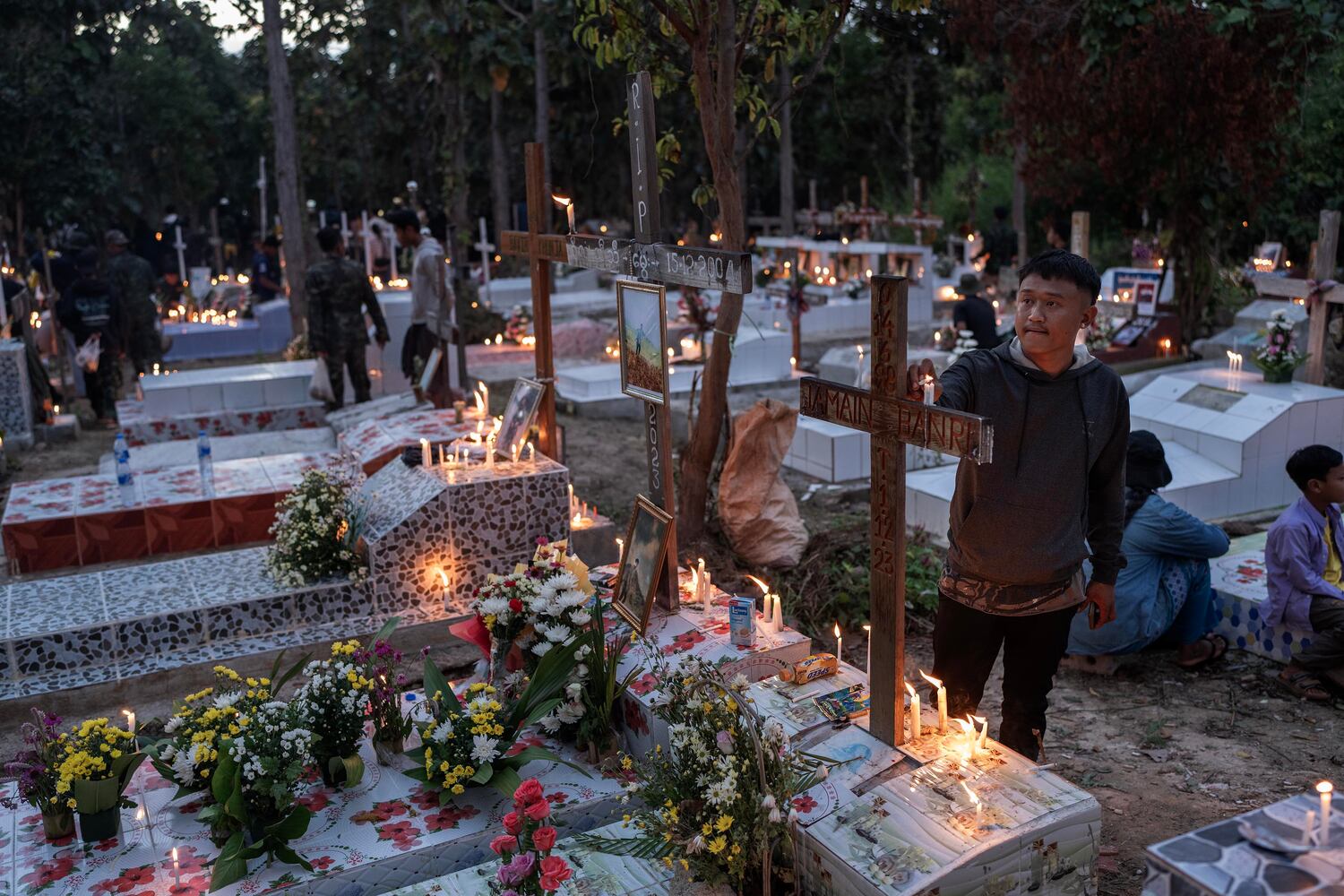 A man lights a candle at a martyrs cemetery to commemorate the fighters who died fighting Myanmar military in Demoso, Kayah state, Myanmar, Nov. 2, 2024. (RFA)