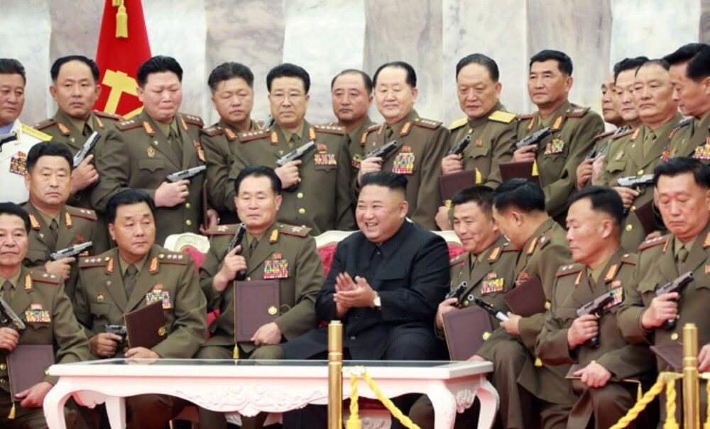 김정은 국무위원장이 26일 북한 당중앙위원회 본부청사에서 조국해방전쟁 승리(정전협정 체결) 67주년을 기념하며 열린 '백두산' 기념권총 수여식에서 군 주요 지휘성원들에게 권총을 수여한 후 권총을 받은 지휘관들에 둘러싸여 웃고 있다. 