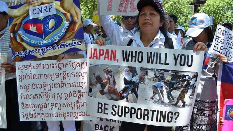 Protesters hold signs calling on Japan to withdraw support for Cambodia's elections in New York, June 16, 2018. Credit: RFA