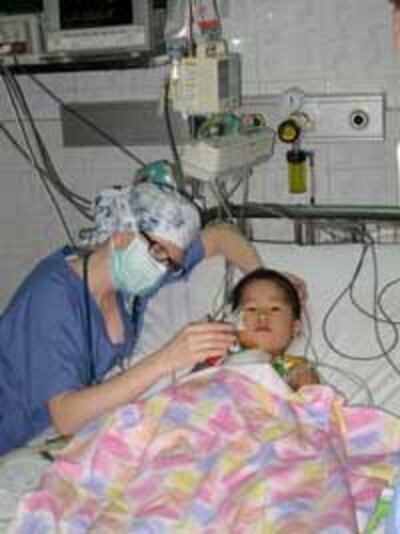 Một em bé được mổ tim miễn phí tại bệnh viện Việt Đức Hà Nội đang được Bác sĩ của tổ chức CardioStart International săn sóc. Photo courtesy of HSCV.org