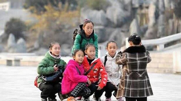 평양 만수대예술극장 앞 공원에서 여자 아이들이 한 데 모여 사진을 찍고 있다.