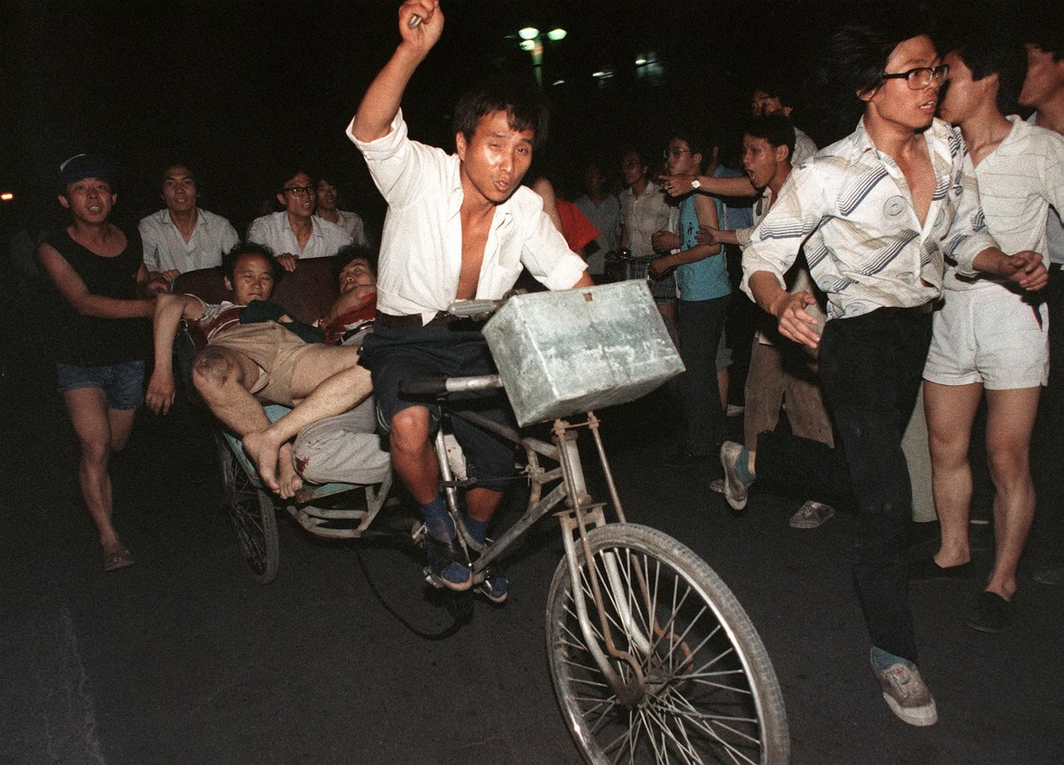 Two injured people are transported during clashes between the army and students near Tiananmen Square in Beijing, June 4, 1989.