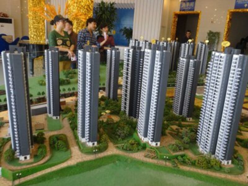Chinese homebuyers look at housing models of a residential property project in Yichang, central China's Hubei province, March 6, 2016.