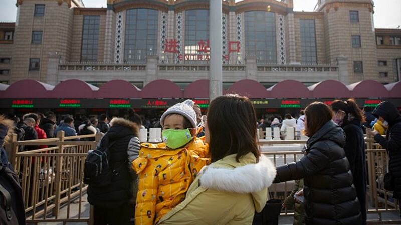 2020年1月21日，北京站外的旅客戴口罩防范感染肺炎。（美联社）