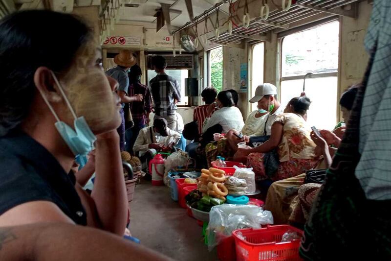 Metro rail commuters ride the Yangon train. During the morning run, most passengers kept their heads down as armed security personnel patrolled the carriages. (Myo Min Soe/RFA)
