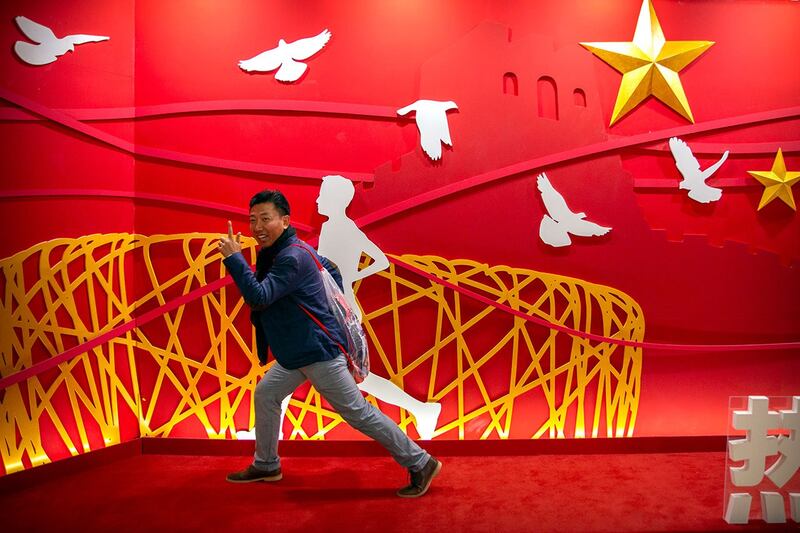 2019 年 10 月 31 日，一名男子在北京马拉松比赛的展示前摆姿势拍照。（美联社）