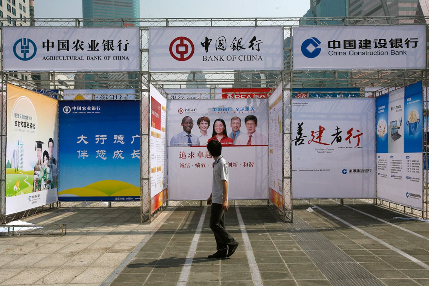 资料照：一男子走过深圳银行促销展位。