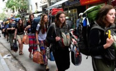 Một nhóm du khách nước ngoài đi bộ ở khu phố cổ của Hà Nội vào ngày 21 Tháng 12 năm 2012. AFP PHOTO / HOANG DINH Nam.