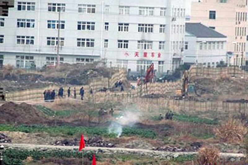 浙江省台州市動員近700人，周四（2013年1月31日）進入江田村強徵土地並施工，工地外有人留守，禁止村民走近。當局出動7部推土機，把200畝土地推平。（（相片由村民徐先生提供）