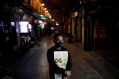 Nhân viên ở một nhà hàng tại Hà Nội cầm bảng quảng cáo trong thời kỳ dich bệnh.