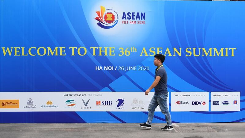 A man walks past a banner for the 36th ASEAN Summit at the International Convention Centre in Hanoi on June 25, 2020, a day before the summit is set to be held online due to the COVID-19 coronavirus pandemic.
