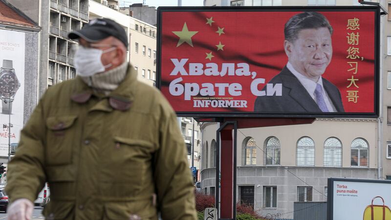 2020年4月1日,塞尔维亚贝尔格莱德,一名戴着防护口罩的男子经过一个广告牌,上面写着“感谢您,习大哥”。(路透社)