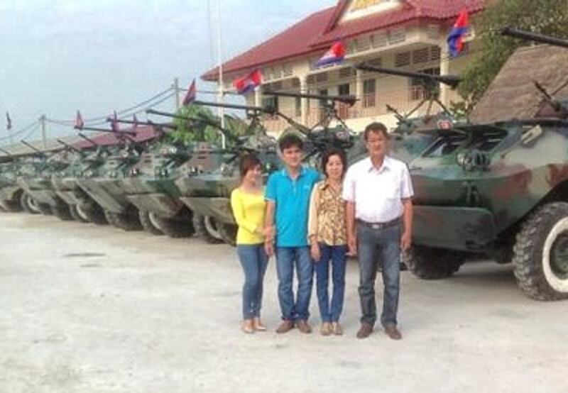 Gia đình ông Trần Quốc Hải bên cạnh những chiếc xe của hai cha con ông sửa chữa và chế tạo (Photo: Ngoc Hau/kenh 13)
