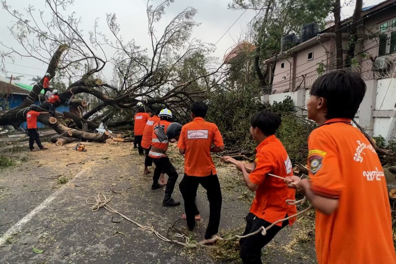 Volunteers work to clear a fallen tree in downtown Sittwe, Myanmar, in the aftermath of Cyclone Mocha, May 16, 2023.
