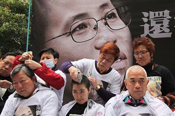 Supporters of Liu Xia and Liu Xiaobo shave their heads on a street in Hong Kong, Feb. 14, 2014.