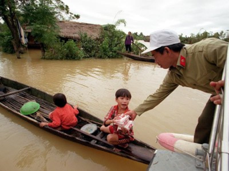 Trẻ em chèo thuyền nhận lương thực cứu trợ mùa lũ ở Quảng Bình. 