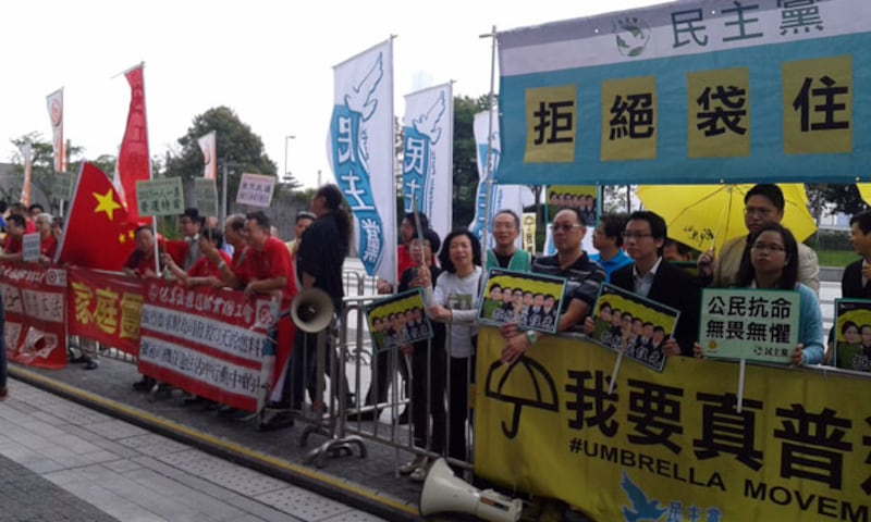 2015年4月22日，民主黨與支持“袋住先”的家庭團聚互助會的成員，只相隔一個鐵馬，互相用擴音器叫口號，鬥大聲。（戴維森攝)