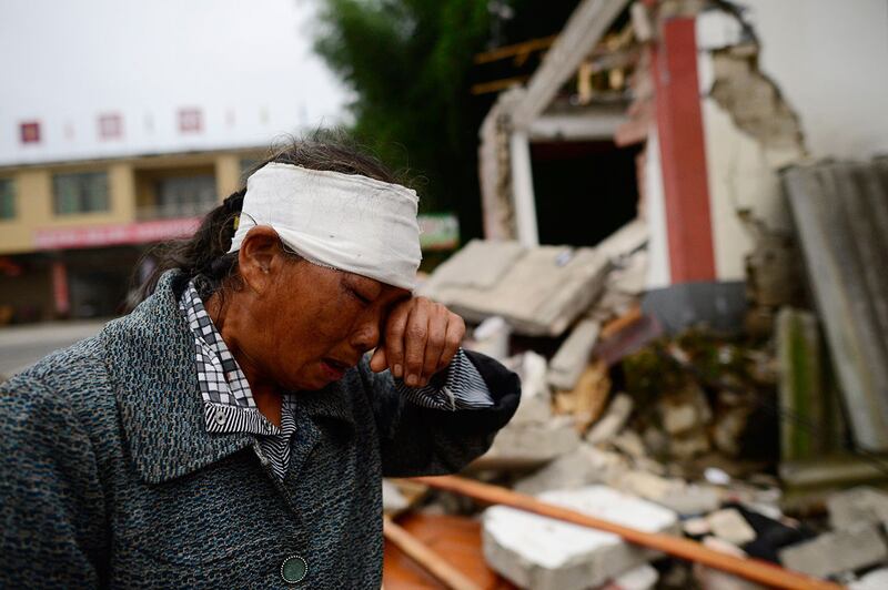 2019年6月17日，四川宜宾长宁县深夜发生6级地震，造成房屋倒塌，逾两百人伤亡。图为18日地震后，一名受伤的妇女在受地震破坏的建筑物附近。（法新社）