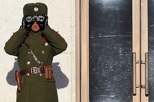 판문점에서 북한 병사가 남쪽초소를 지켜보고 있다.