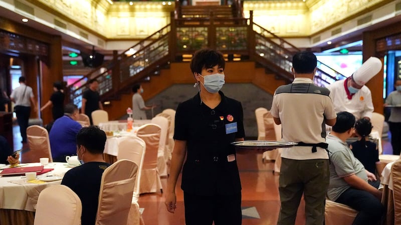 2020年8月18日，北京全聚德烤鸭店，餐厅大堂“制止浪费监督员”，佩戴胸牌，对餐厅内的浪费情况进行监督。（路透社）