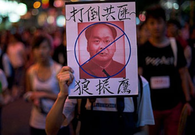 7月1日香港數十萬民眾大遊行表達政治訴求。遊行中有示威者高舉反對特首梁振英的標語牌。(法新社)