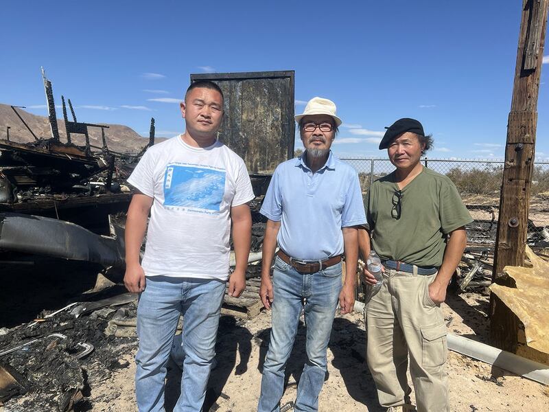 2024年8月21日，黄河（左）、晏奇恩（中）、陈维明（右）在自由雕塑公园被烧毁的房车前。（孙诚拍摄）