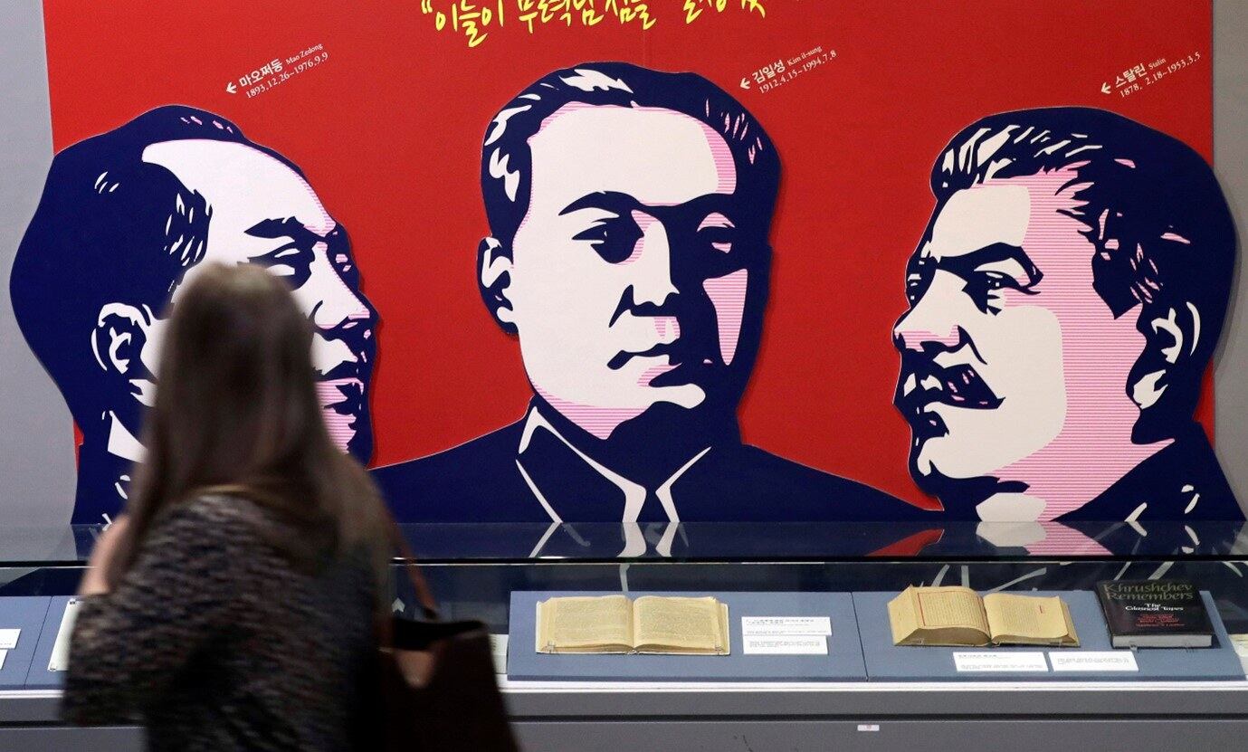 2019년 4월 23일 서울 한국전쟁 전시장을 둘러보던 관람객이 (왼쪽부터) 중국 마오쩌둥, 북한 김일성, 이오시프 스탈린의 모습이 담긴 현수막을 바라보고 있다.