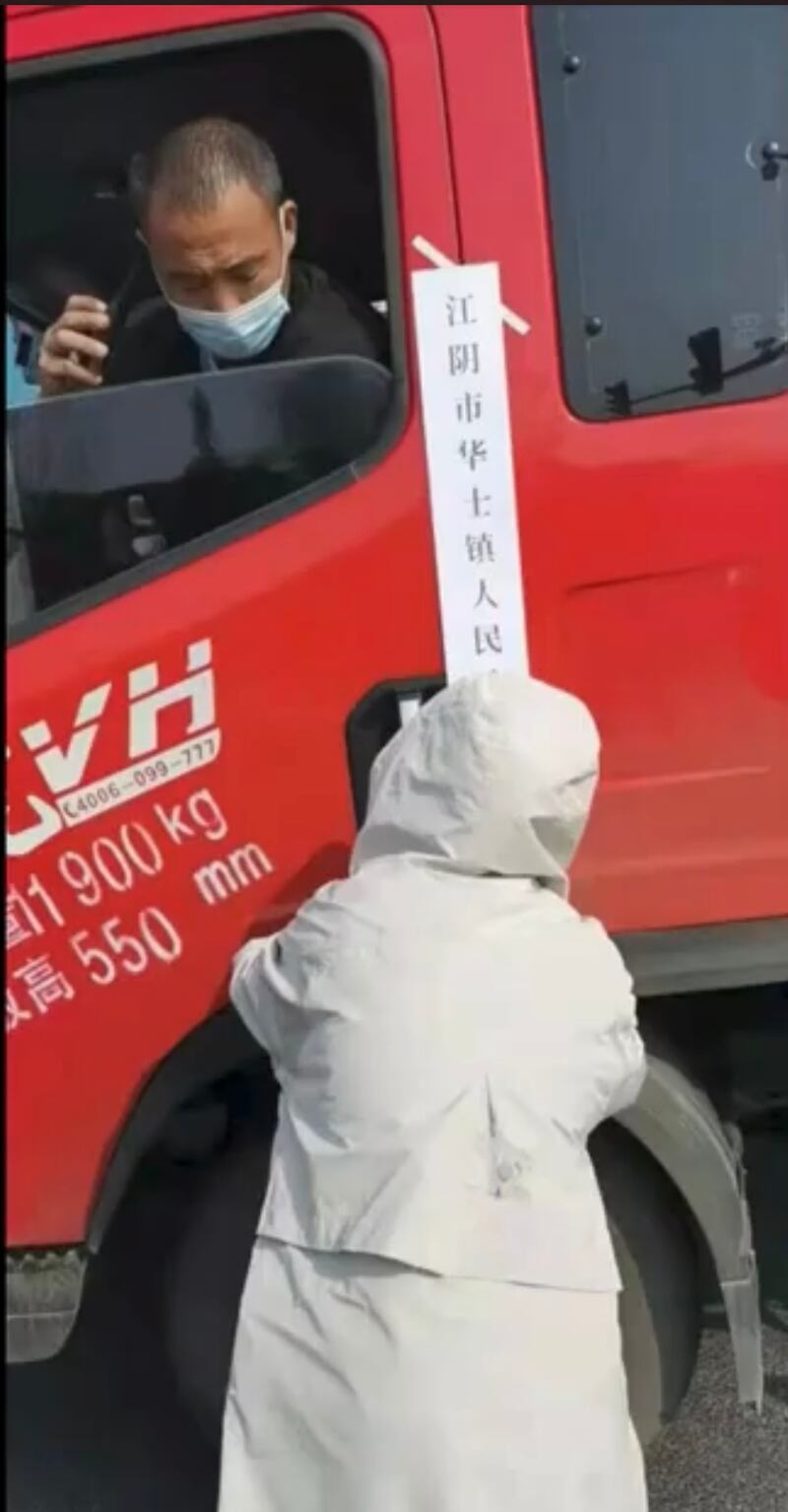 江陰市華士鎮防疫人員將一貨車司機隔離在駕駛室內。(影片截圖)