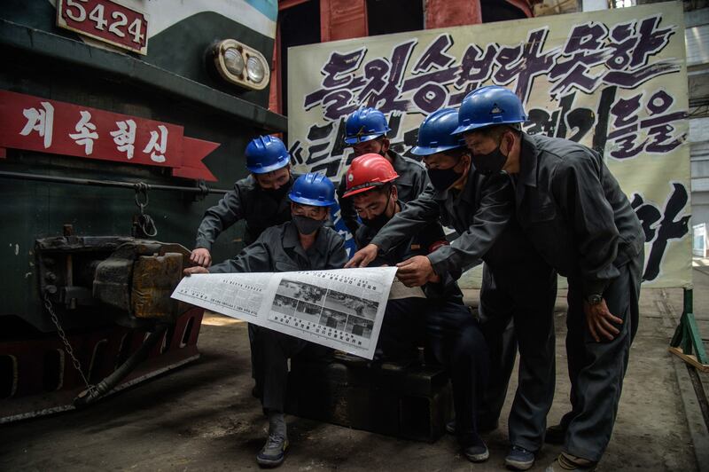 김종태전기기관차연합기업소 직원들이 노동신문을 읽고 있다.