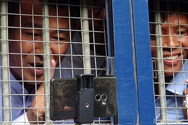 Journalists Aye Nai (L) and Lawi Weng speak to reporters from inside a prisoner transport vehicle outside the courthouse in the town of Thibaw in Myanmar's northeastern Shan State, July 28, 2017.
