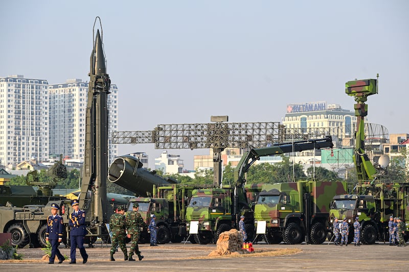 Vietnam's military officials walks near (L-R) a Russian R-17E (Scud-B) surface-to-surface missile, a 4K44b Redut coastal missile complex and a radar during the Vietnam 2024 International Defense Expo in Hanoi on Dec. 19, 2024.