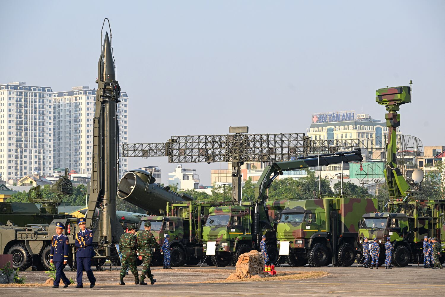 Vietnam's Military officials walks near (L-R) Russian R-17E (Scud-B) surface-to-surface missile, 4K44b Redout coastal missile complex and a radar during the Vietnam 2024 International Defense Expo in Hanoi on December 19, 2024.