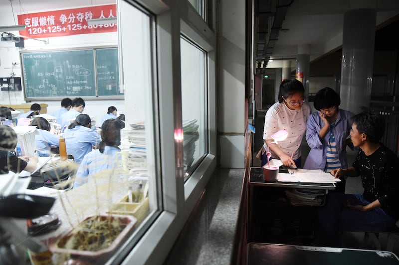 This May 23, 2018, photo shows a high school teacher answering questions ahead of the  college entrance examinations in China's northern Hebei province.