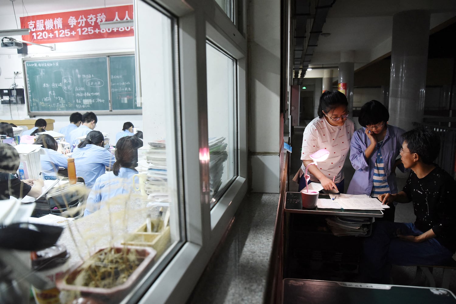 A high school teacher helps a student ahead of the college entrance examinations in China's northern Hebei province, May 23, 2018.
