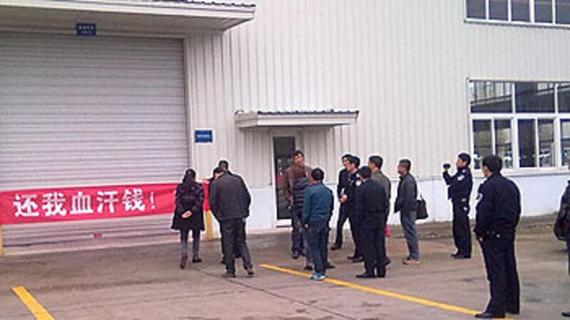 四川省安縣十多名農民工代表，11月7日到國營企業的廠房外拉橫額討薪。（相片由六四天網提供）