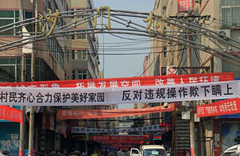 2012年9月19日，河南鄭州市沙門村村民反對村委會提出的拆遷計劃，於村內街道上掛起反拆遷標語，而村委會亦於街道上掛起“唱好”拆遷橫幅。(沙門村商戶“大紅果”提供)